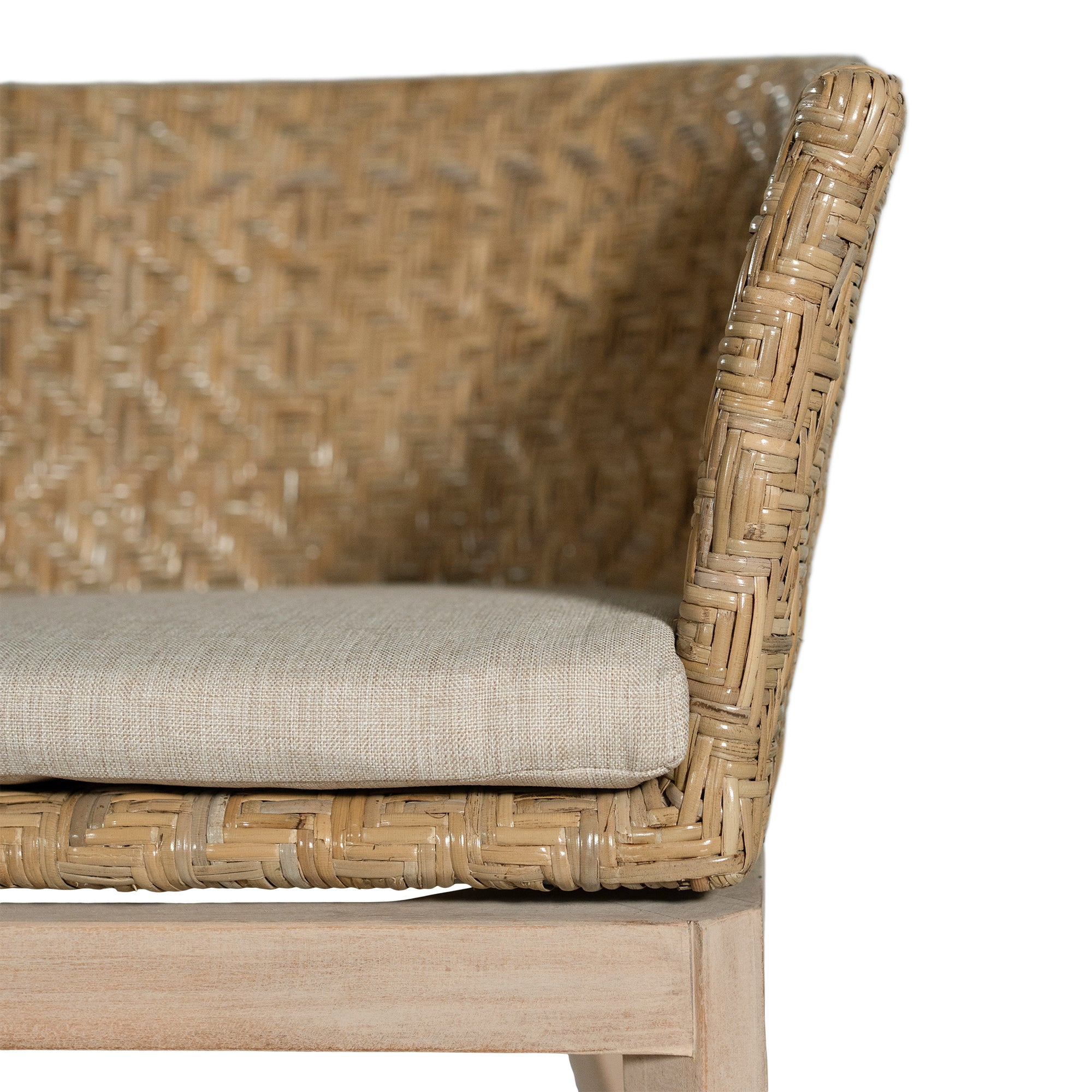 KULALA Living handwoven rattan dining chair with a curved backrest, natural wood legs, and a neutral seat cushion, blending coastal and contemporary design