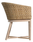 KULALA Living handwoven rattan dining chair with a curved backrest, natural wood legs, and a neutral seat cushion, blending coastal and contemporary design