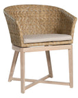 KULALA Living handwoven rattan dining chair with a curved backrest, natural wood legs, and a neutral seat cushion, blending coastal and contemporary design