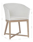 KULALA Living handwoven rattan dining chair with a curved backrest, natural wood legs, and a white seat cushion, blending coastal and contemporary design